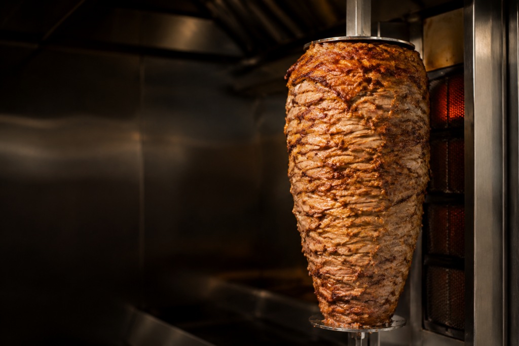 Illustrative image of a large donair meat cone on a vertical rotisserie